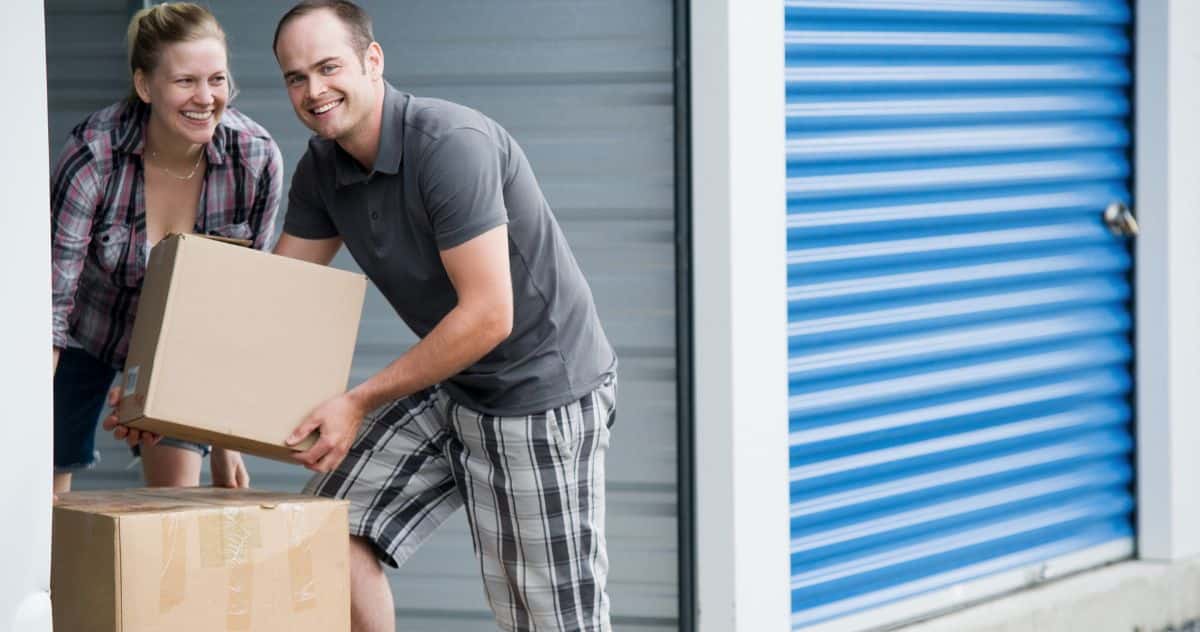 Couple carrying moving boxes at a self storage unit