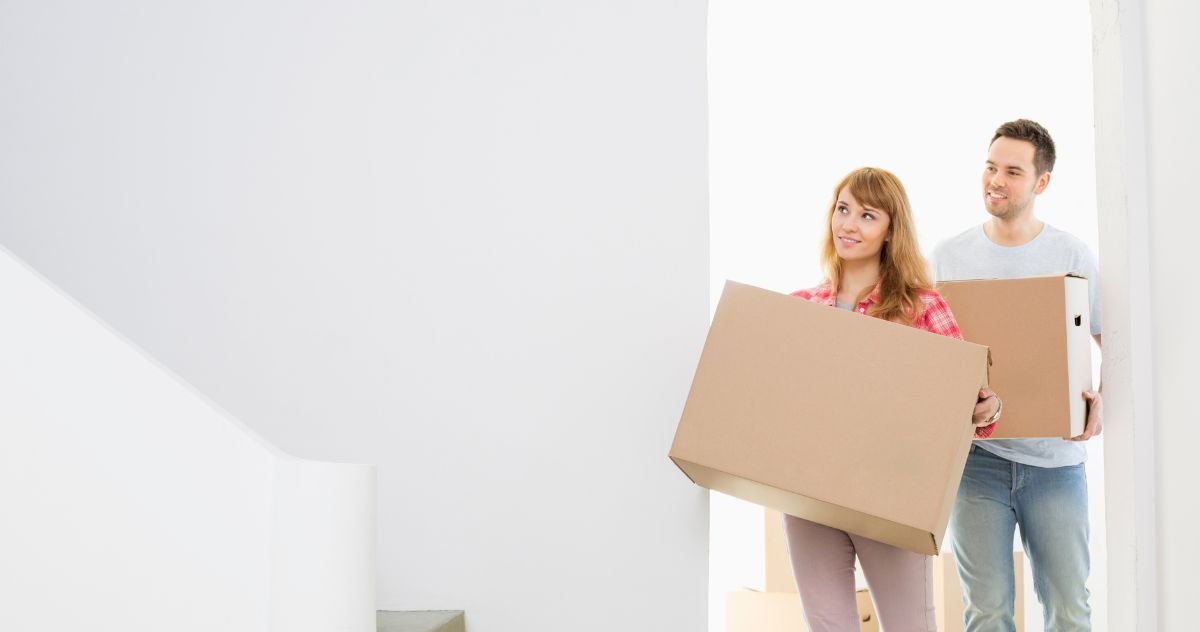 Couple carrying moving boxes